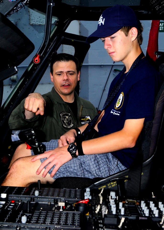 US Navy 110515-N-3154P-173 Lt. Brian Gervais explains the flight controls of an MH-60S Sea Hawk helicopter to a civilian embarked for a Tiger Cruis