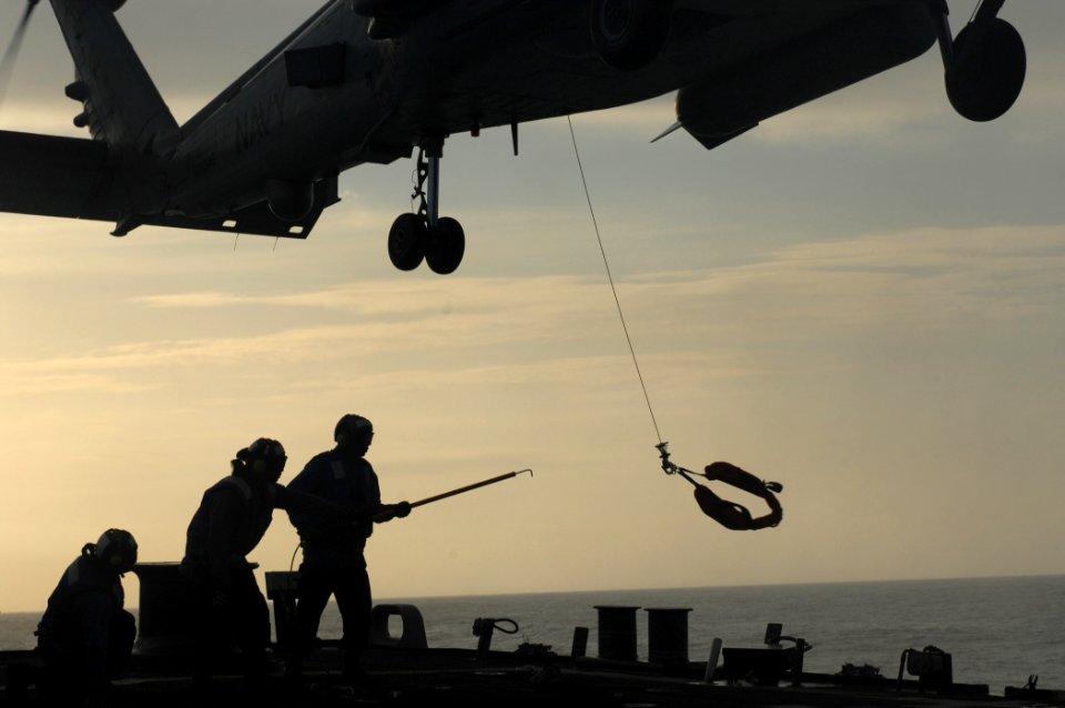 US Navy 110514-N-XQ375-260 Sailors hook a line attached to an MH-60R Sea Hawk helicopter from Helicopter Maritime Strike Squadron (HSM) 70