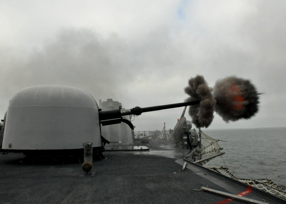 US Navy 110511-N-NL541-209 The Oliver Hazard Perry-class guided-missile frigate USS Thach (FFG 43) fires its MK-75 76mm mounted gun while underway