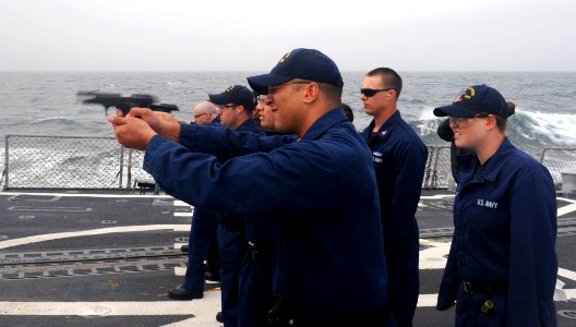 US Navy 110515-N-TB177-506 Chief Gunner's Mate Kevin M. Benoit fires a 9 mm pistol during a small arms qualification aboard the guided-missile dest