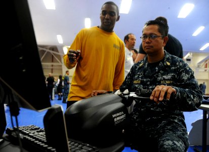 US Navy 110513-N-VE260-020 Aviation Electrician's Mate 2nd Class Johnny Guante instructs Senior Chief Culinary Specialist Celestino Angeles as he u