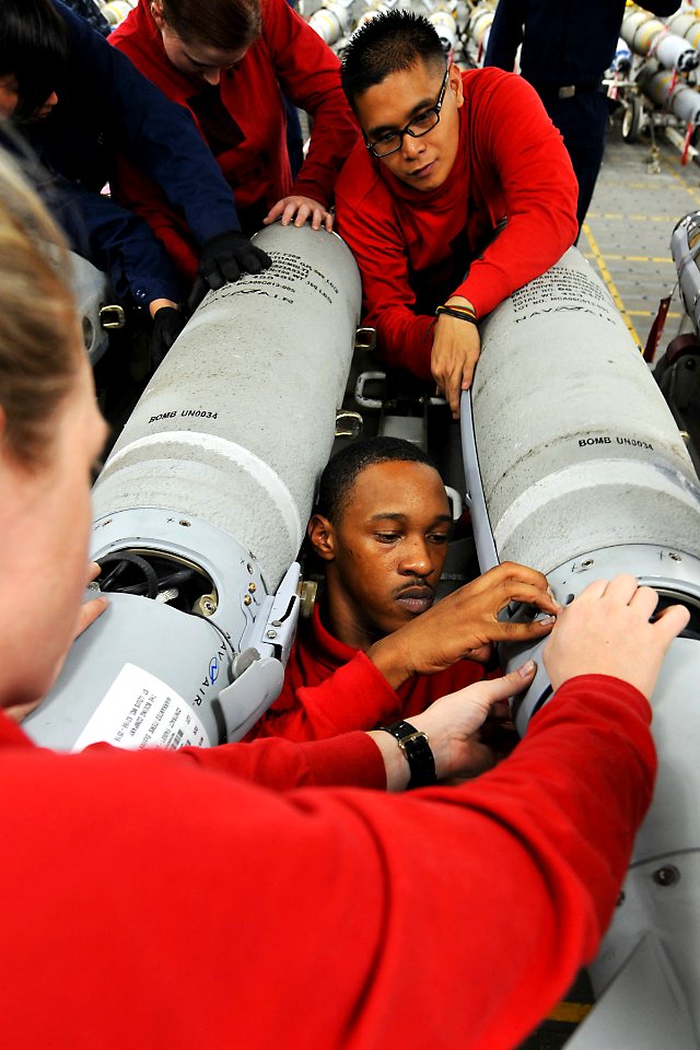 US Navy 110512-N-1004S-085 Aviation Ordnanceman 2nd Class Misty Beck, left, Airman Carl Winchester and Airman Joseph Flores work together while ins