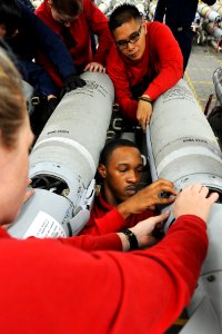 US Navy 110512-N-1004S-085 Aviation Ordnanceman 2nd Class Misty Beck, left, Airman Carl Winchester and Airman Joseph Flores work together while ins