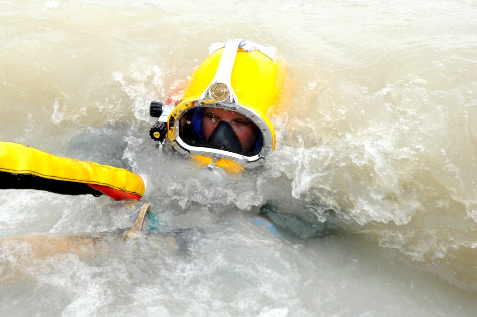 US Navy 110514-N-WL435-681 Navy Diver 2nd Class Anthony Hanni submerges underwater to blast away thick layers of mud and clay from a sunken pier at