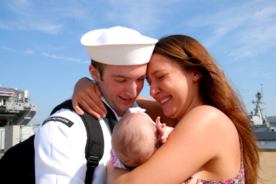 US Navy 110516-N-VK779-090 Machinist's Mate Fireman Roberto Valentine holds his daughter for the first time during a homecoming celebration for the