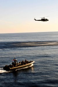 US Navy 110514-N-XO436-337 A rigid-hull inflatable boat and an UH-1N Huey helicopter assigned to the San Antonio-class amphibious transport dock sh