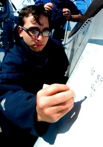 US Navy 110512-N-OS574-118 Yeoman 2nd Class William Viney writes the ship's course and speed during a replenishment at sea aboard the San Antonio-c