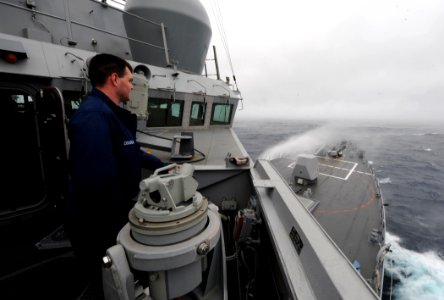 US Navy 110512-N-TB177-143 Quartermaster Seaman Carlton E. Coughlin watches sea spray wet the bow of the guided-missile destroyer USS Truxtun (DDG photo