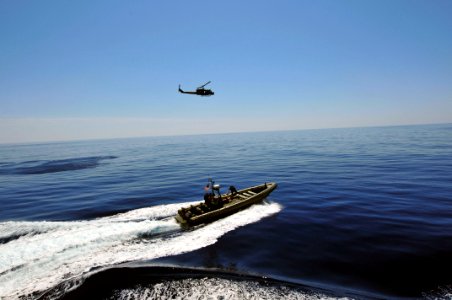 US Navy 110514-N-XO436-179 A rigid-hull inflatable boat and a UH-1N Huey helicopter assigned to San Antonio-class amphibious transport dock ship US