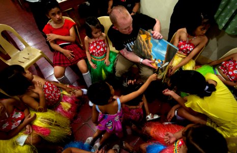 US Navy 110517-N-TU221-793 Hospital Corpsman 3rd Class Jonathan Martin reads a book to orphans at Hospicio De San Jose Orphanage photo