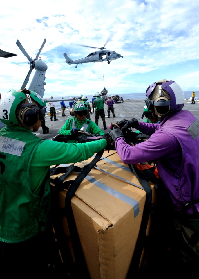 US Navy 110517-N-YM863-203 Air crewmen aboard the amphibious transport dock ship USS Cleveland (LPD 7) undo netting on supplies while undergoing a