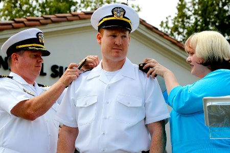 US Navy 110514-N-HW977-362 Lt. j.g. B. Shane Anderson has his wife, Felicia Anderson, and Cmdr. Jon Jerge pin his shoulder boards during his commis photo