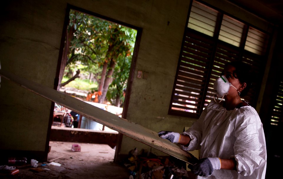 US Navy 110517-N-TU221-268 Personnel Specialist Seaman Monica Roberts removes paneling from a wall inside an abandoned building at Hospicio De San
