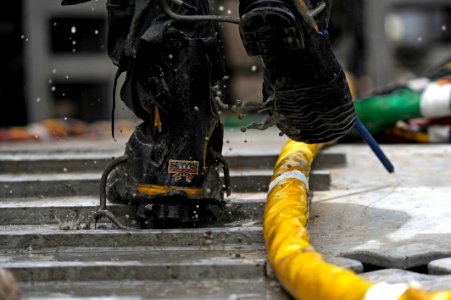 US Navy 110518-N-WL435-051 Mud, sand, and silt drip from the boots of a diver assigned to Commander, Task Group (CTG) 56.1