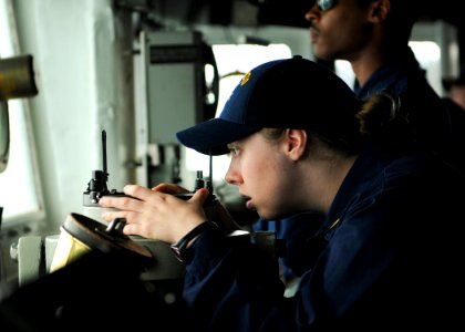 US Navy 110515-N-YM590-102 Ensign Meredith C. Manuel peers through a telescopic alidade on the bridge aboard the guided-missile cruiser USS Anzio (