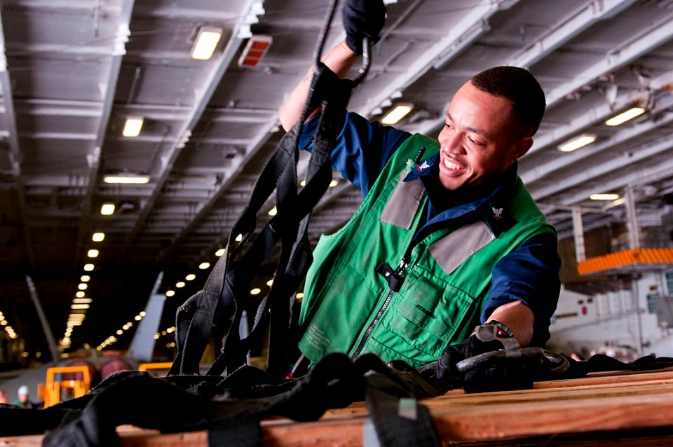 US Navy 110519-N-BT887-031 Logistics Specialist 3rd Class Andrew Wright, from Memphis, Tenn., places a cargo net around a pallet of retrograde for