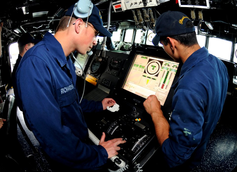 US Navy 110517-N-TB177-188 Gas Turbine System Technician (Electrical) Fireman Matt R. Richardson, left, receives training at the helm aboard USS Tr