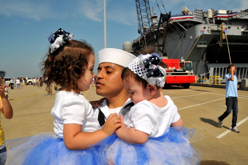 US Navy 110516-N-QY430-218 Mass Communication Specialist Seaman Jonathan Vargas holds his daughters during a homecoming celebration for the amphibi