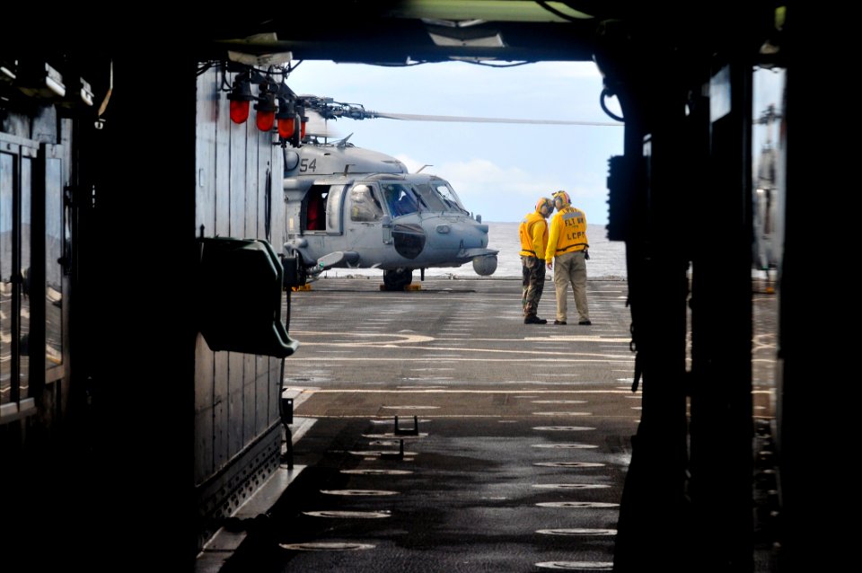 US Navy 110517-N-ZZ999-005 A chief petty officer speaks with a Sailor near an MH-60S Sea Hawk helicopter assigned to the Wild Cards of Helicopter S