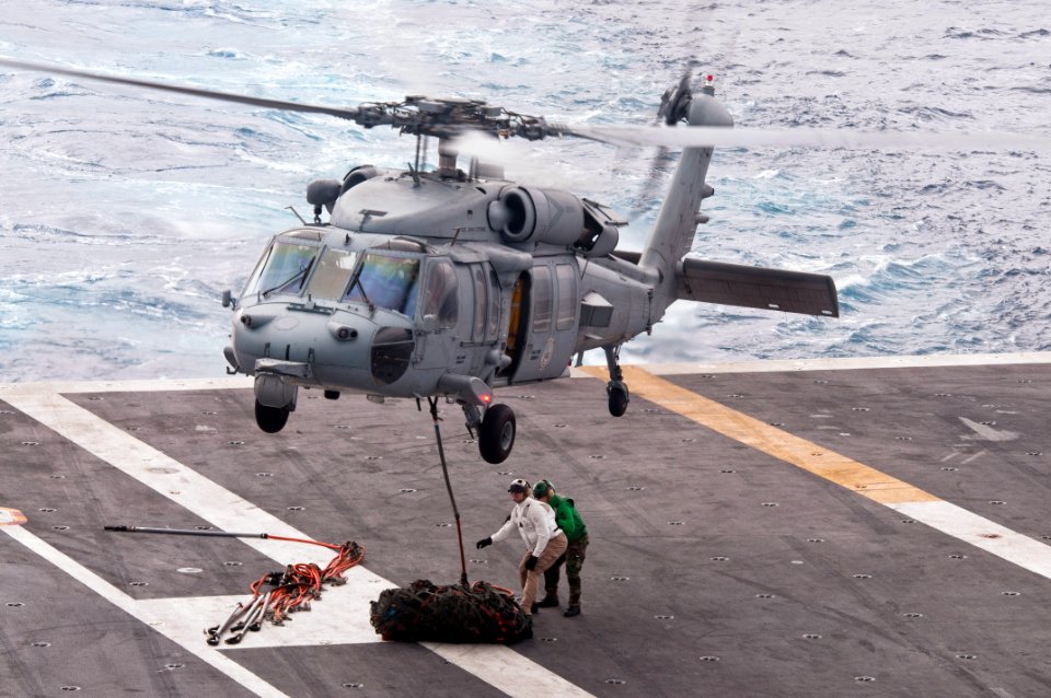 US Navy 110519-N-BT887-014 Sailors attach cargo to an MH-60S Sea Hawk helicopter from the Eightballers of Helicopter Sea Combat Squadron (HSC) 8
