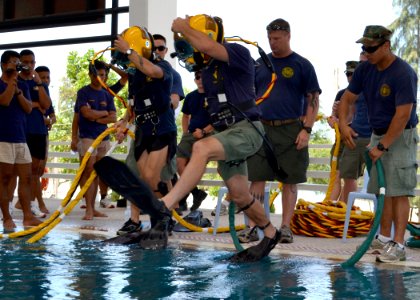 US Navy 110517-N-VA590-098 Navy Diver 1st Class Dale Park, center, assigned to Southwest Regional Maintenance Center, jumps into a dive training po