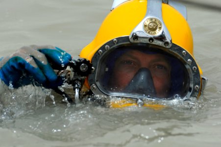 US Navy 110518-N-WL435-218 Chief Navy Diver Ryan Oakley, assigned to Commander, Task Group 56.1, makes an adjustment to his Kirby Morgan 37 diving