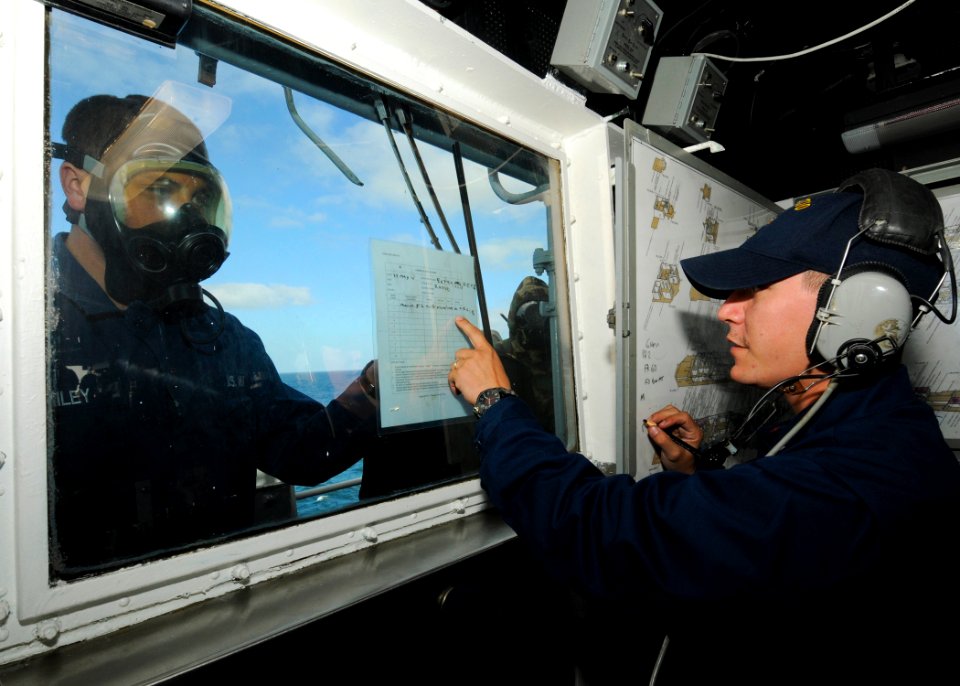 US Navy 110519-N-YM590-053 Damage Controlman 3rd Class Adam W. Bailey shows contamination results to Quartermaster 3rd Class Joseph P. Gregory duri