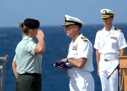 US Navy 110518-N-YM863-182 Spc. Heather Correll salutes as Capt. S. Robert Roth receives a ceremonial flag on behalf of the family of the deceased