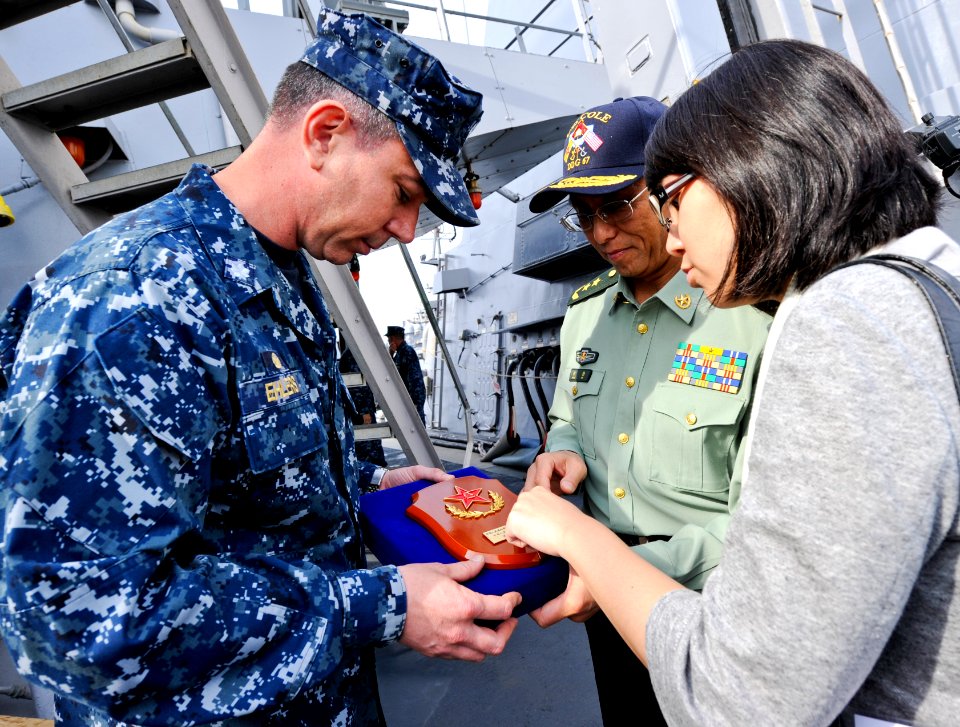 US Navy 110519-N-CI175-157 A translator reads the inscription on a plaque by Lt. Gen. Qin Zheng, presented to Cmdr. Drew Ehlers following a tour of