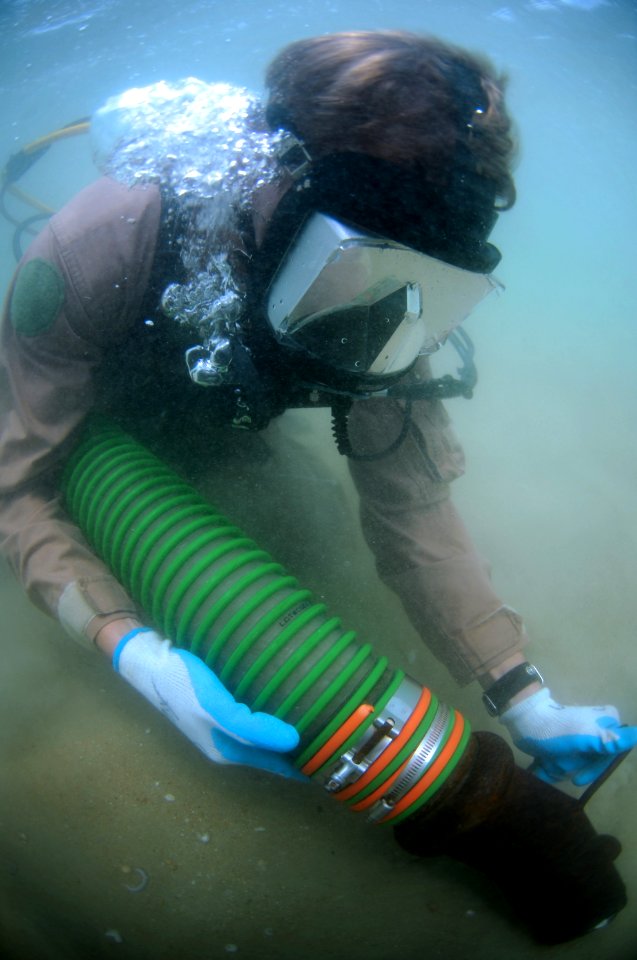 US Navy 110520-N-VF350-123 Navy Diver 2nd Class Jordan Wingard sucks sand off the bottom of the ocean during a Joint POW-MIA Accounting Command und