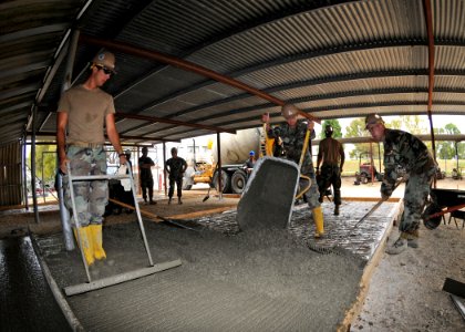 US Navy 110520-N-AW868-082 Seabees assigned to Naval Mobile Construction Battalion (NMCB) 74, Detachment Senegal, pour concrete at a project site a photo