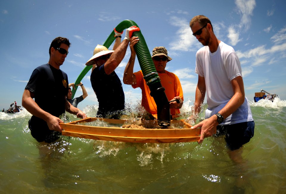 US Navy 110520-N-VF350-095 Personnel assigned to the Joint POW-MIA Accounting Command (JPAC) empty a suction hose of sediment into a screen during