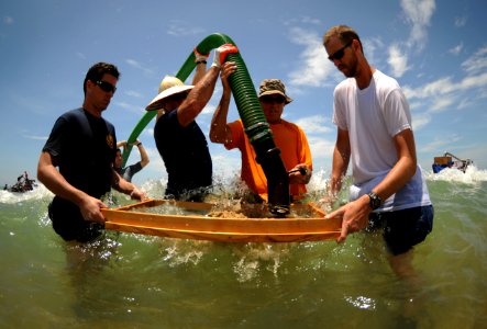 US Navy 110520-N-VF350-095 Personnel assigned to the Joint POW-MIA Accounting Command (JPAC) empty a suction hose of sediment into a screen during
