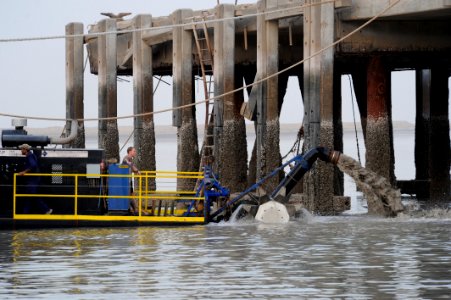 US Navy 110519-N-WL435-474 Chief Navy Diver Ryan Oakley, assigned to Commander, Task Group (CTG) 56.1, monitors the output of a dredger as it disch