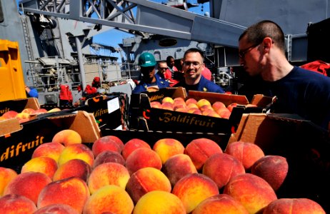 US Navy 110519-N-AG285-277 Sailors aboard the amphibious dock landing ship USS Whidbey Island (LSD 41) move crates of peaches during a vertical rep