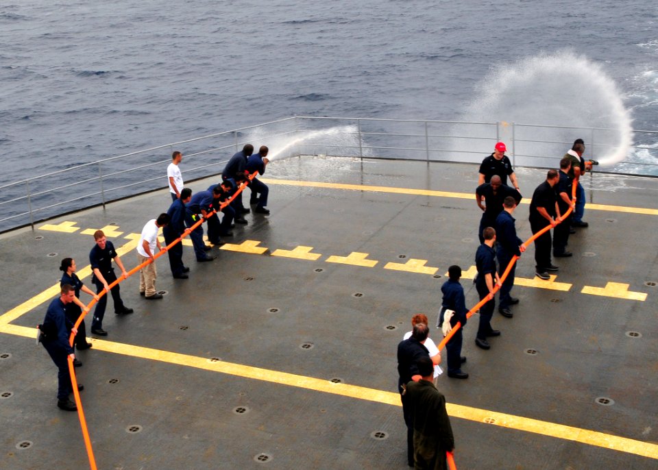 US Navy 110524-N-BK435-148 Sailors and civilian mariners assigned to the submarine tender USS Frank Cable (AS 40) practice hose handling procedures
