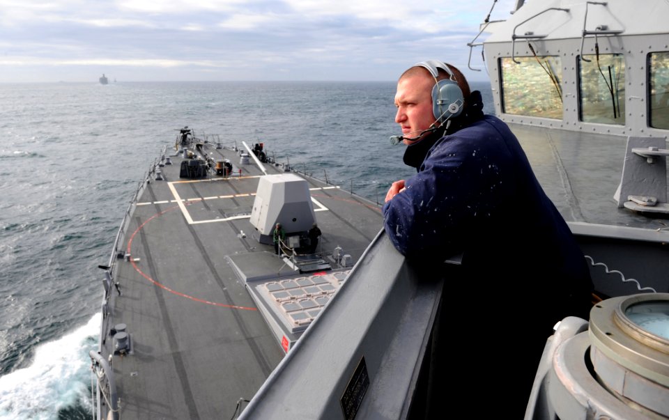 US Navy 110521-N-TB177-042 Culinary Specialist 3rd Class Craig M. Browning stands lookout on the ship's bridge wing aboard USS Truxtun (DDG 103) du