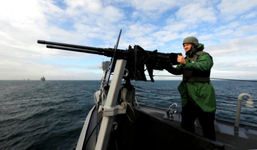 US Navy 110521-N-TB177-128 Gunner's Mate 1st Class William E. Whitlock stands watch at a double barrel 50-caliber machine gun aboard SS Truxtun (DD