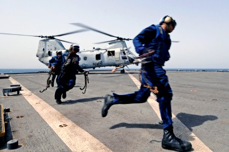 US Navy 110523-N-RC734-129 Flight deck personnel aboard the amphibious dock landing ship USS Comstock (LSD 45) run to clear the rotor blades of a C