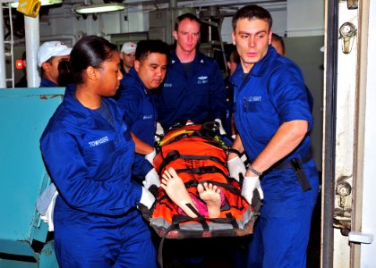 US Navy 110524-N-BK435-025 Sailors assigned to the submarine tender USS Frank Cable (AS 40) carry a medical simulation dummy to an elevator during