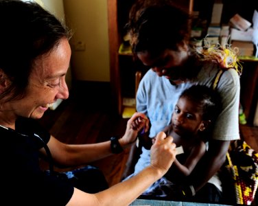 US Navy 110523-F-HS649-128 Pediatric nurse Lt. Cmdr. Rivka Weiss plays with a Papua New Guinean baby during a Pacific Partnership 2011 medical civi