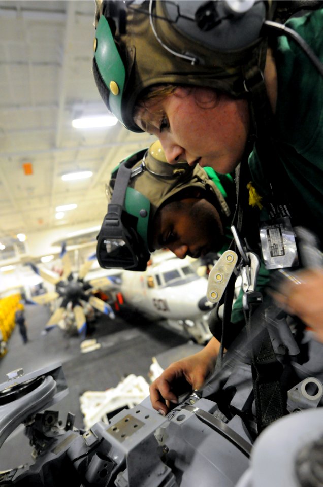US Navy 110523-N-XE109-034 Aviation Machinist's Mate 3rd Class Christina Beck, right, and Aviation Ordnanceman Airman Aaron Smith work on an MH-60R