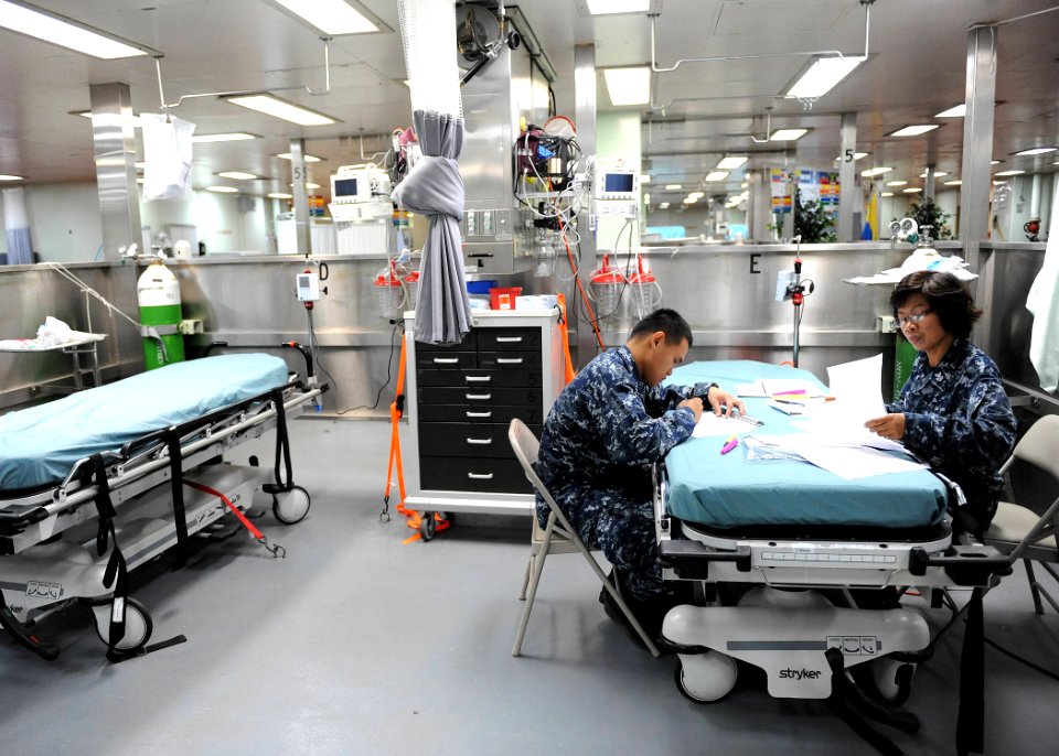 US Navy 110524-F-ET173-090 Hospital Corpsman 1st Class Florence Pacrem, right, and Hospital Corpsman 2nd Class Marvin Silvosa review patient record