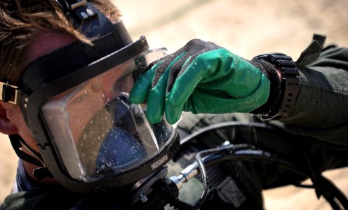US Navy 110520-N-VF350-309 Chief Navy Diver Jason Shafer wipes off his MK-20 diving mask before a dive while searching for missing in action Americ