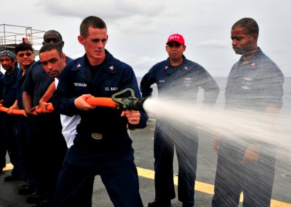 US Navy 110524-N-BK435-123 Sailors and civilian mariners assigned to the submarine tender USS Frank Cable (AS 40) practice hose handling procedures