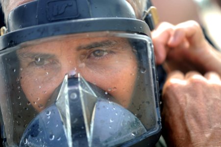 US Navy 110521-N-VF350-022 Brick Bradford tightens his MK-20 diving mask before a dive during a recovery mission