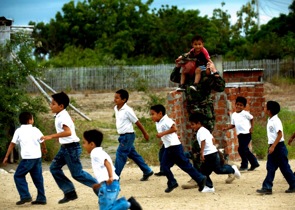 US Navy 110524-N-NY820-492 Senior Chief Master-at-Arms Gerald Rainford plays with kids at a school in Manta, Ecuador, during a community service ev photo