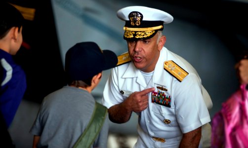 US Navy 110525-N-TU221-310 Rear Adm. Samuel Perez, commander of Carrier Strike Group (CSG) 1, explains the meaning of a warfare device to children