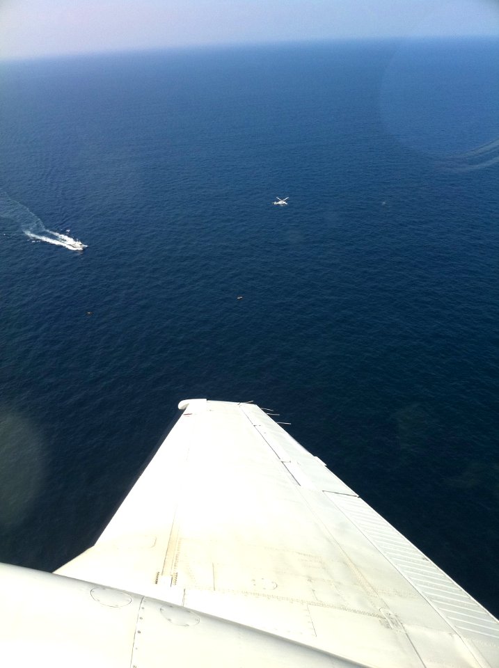 US Navy 110523-N-YY000-001 A C-12 Huron from Naval Air Facility Misawa circles over two kayaks lost at sea as a Japanese Coast Guard vessel and h