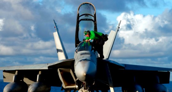 US Navy 110530-N-TU221-466 A Sailor steps into the cockpit of an F-A-18F Super Hornet assigned to Strike Fighter Squadron (VFA) 22 aboard the Nimit